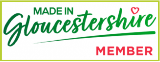 Logo for 'Made in Gloucestershire' member with green text and red heart symbol on a white background